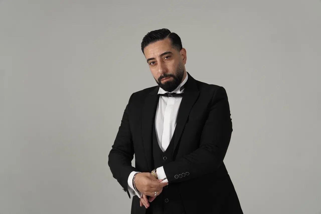 Gri stüdyo fonunda kol düğmesini düzeltirken